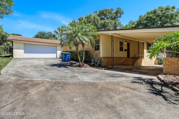 a view of a house with backyard and plants