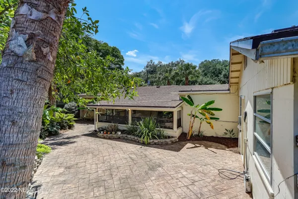 a view of a house with backyard and trees