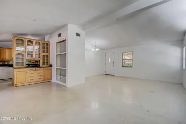 a view of kitchen with refrigerator and white cabinets