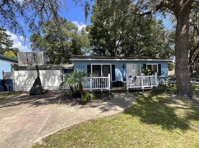 a view of a house with backyard and sitting area