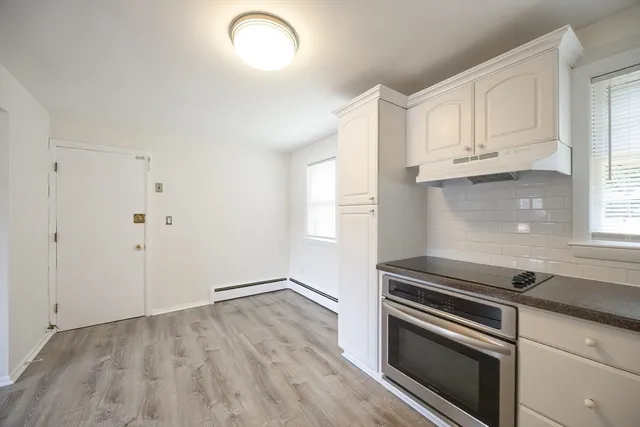 a kitchen with granite countertop white cabinets and stainless steel appliances