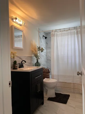 a bathroom with a sink toilet and shower