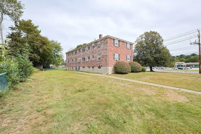 a large building with a big yard and large trees