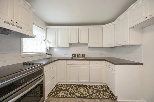 a kitchen with granite countertop a sink and cabinets