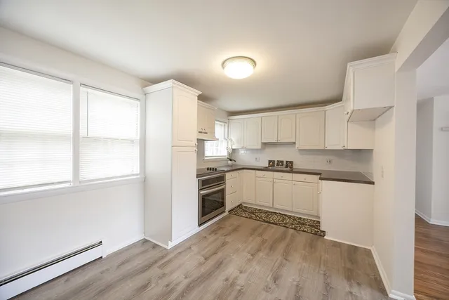 a kitchen with granite countertop white cabinets and white appliances