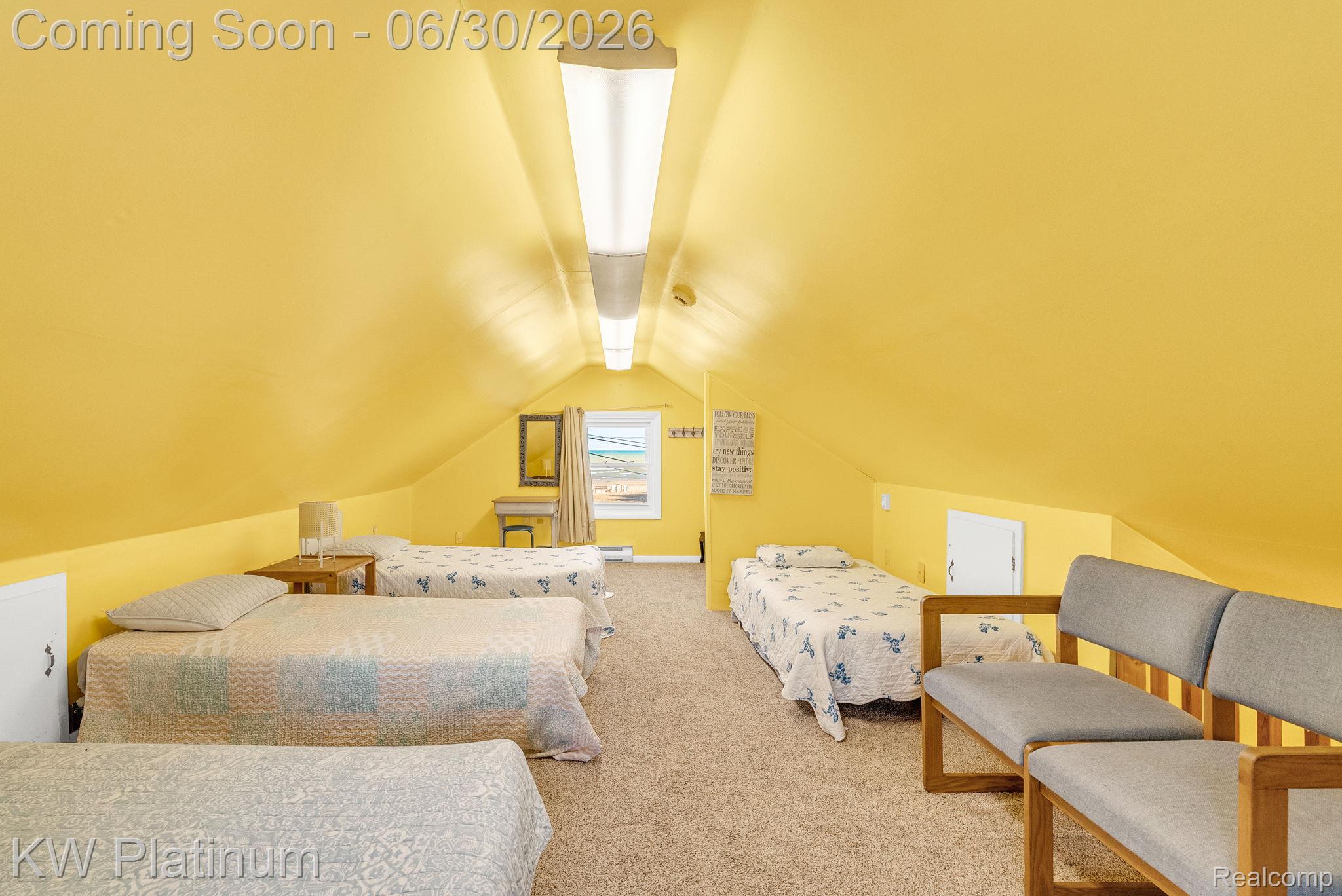 2235 South Lake Shore Road Harbor Beach, MI 48441 - Photo 67 of 99 Room featuring a bright yellow sloped ceiling, light-toned carpet flooring, and a window with a distant landscape visible