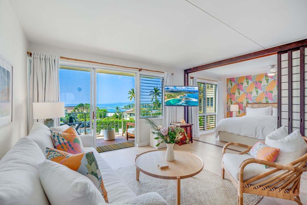 1763 Pe'e Road, Unit 203 Koloa, HI 96756 - Photo 1 of 27 a living room with furniture and a large window