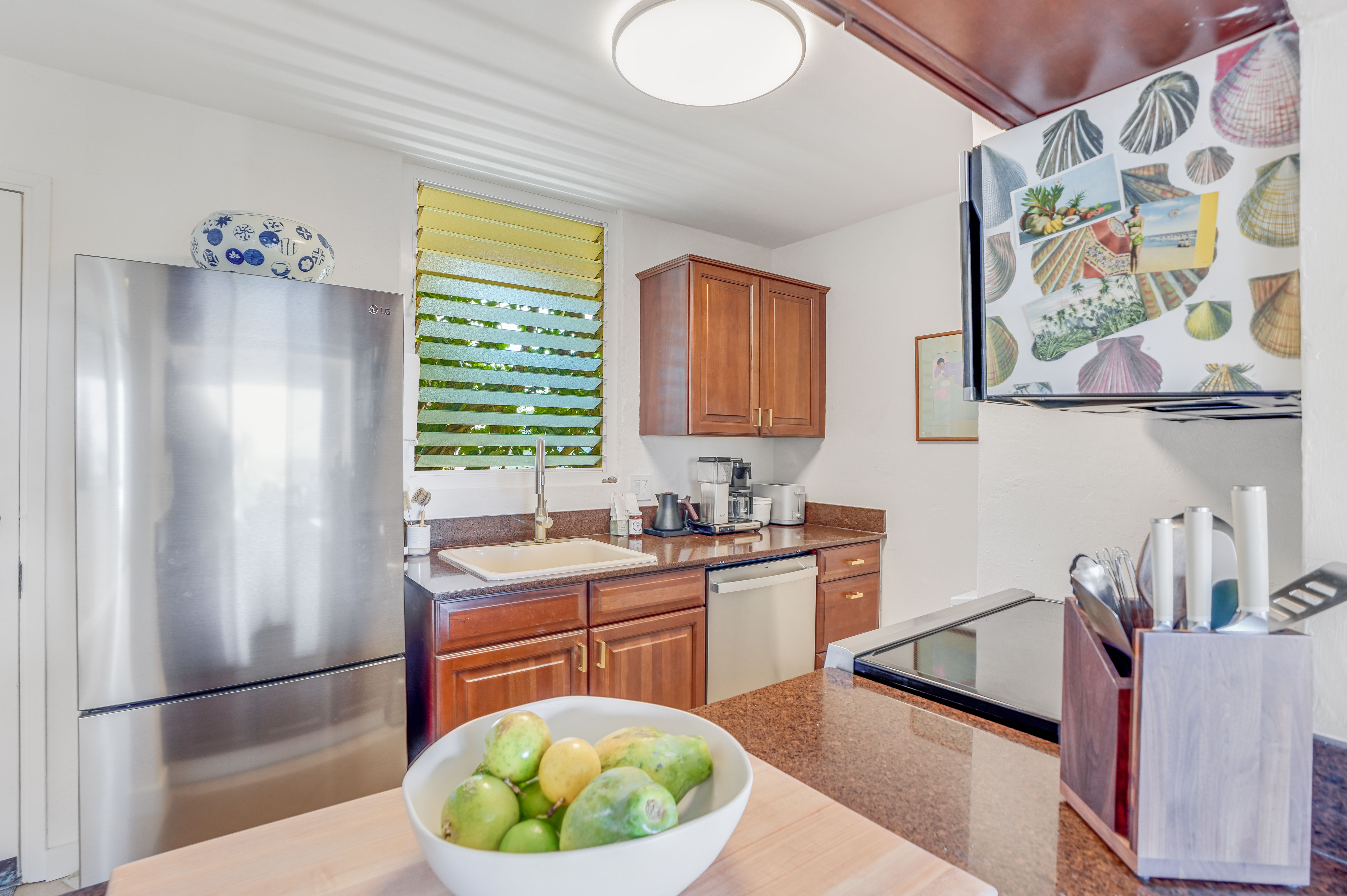 1763 Pe'e Road, Unit 203 Koloa, HI 96756 - Photo 15 of 27 a kitchen with stainless steel appliances granite countertop a sink refrigerator and window
