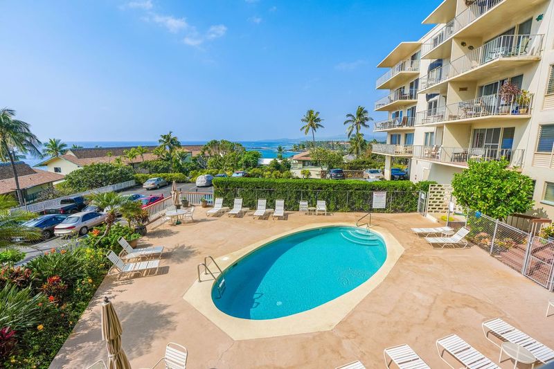 1763 Pe'e Road, Unit 203 Koloa, HI 96756 - Photo 19 of 27 a view of a swimming pool with a garden