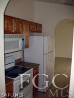 4105 26th Street Southwest Lehigh Acres, FL 33976 - Photo 3 of 5 a kitchen with a sink a stove and a refrigerator