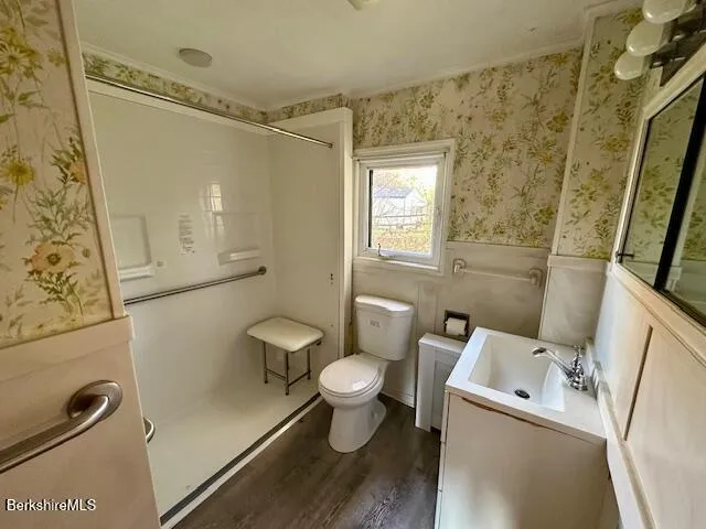 a white toilet sitting next to a bathroom sink and a shower