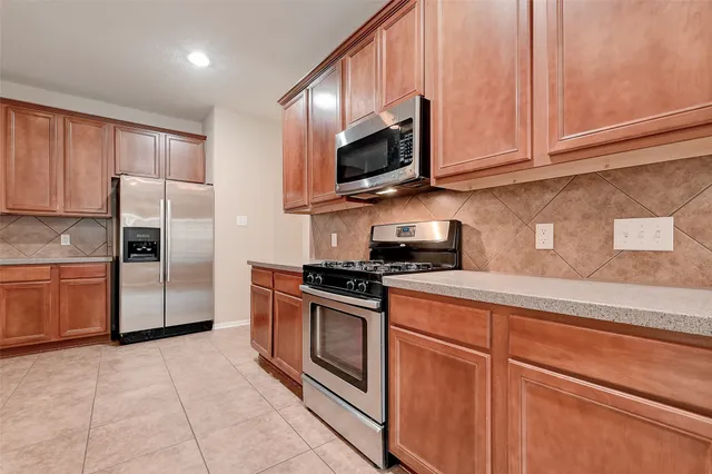 a spacious bathroom with a granite countertop sink a mirror and a bathtub