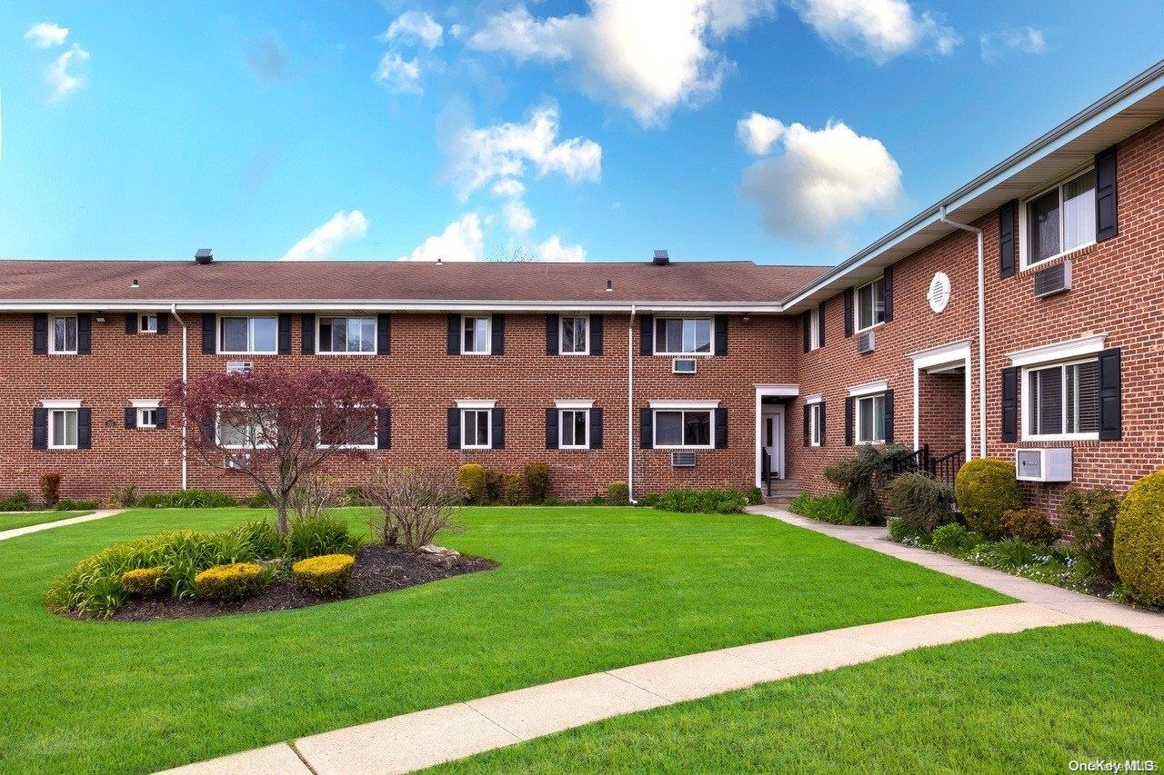 200 Merrick Road, Unit M Amityville, NY 11701 - Photo 1 of 1 a front view of a house with a garden and yard
