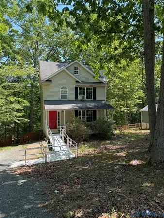 a view of house with yard and trees in the background