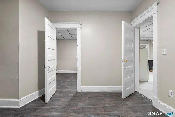 an empty room with wooden floor and entrance