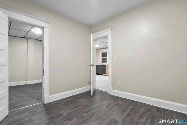 an empty room with wooden floor and closet