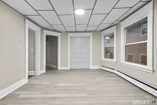 a view of empty room with wooden floor and fan