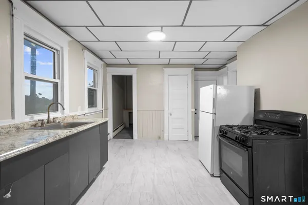 a kitchen with stainless steel appliances granite countertop a stove a sink and a refrigerator