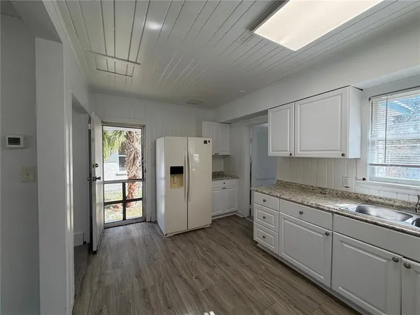 a kitchen with cabinets and wooden floor