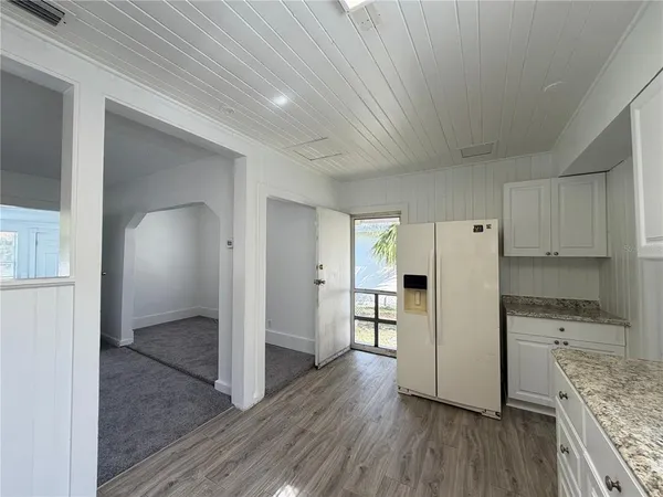 a view of a kitchen with wooden floor and electronic appliances
