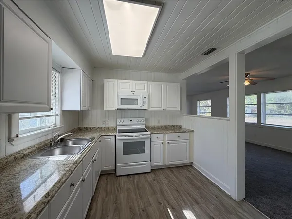 a kitchen with stainless steel appliances granite countertop a stove a sink dishwasher and a refrigerator