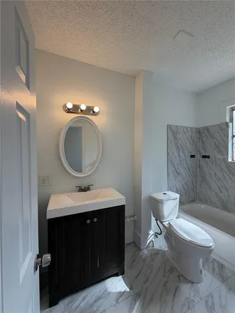 a bathroom with a toilet a sink and mirror