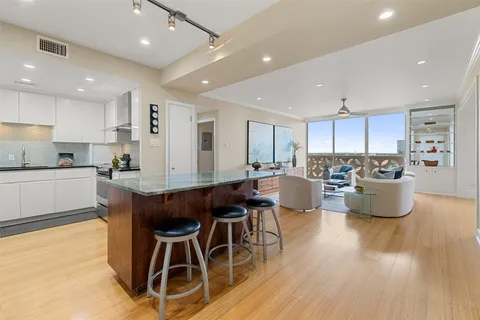 a kitchen with stainless steel appliances a dining table chairs and wooden floor