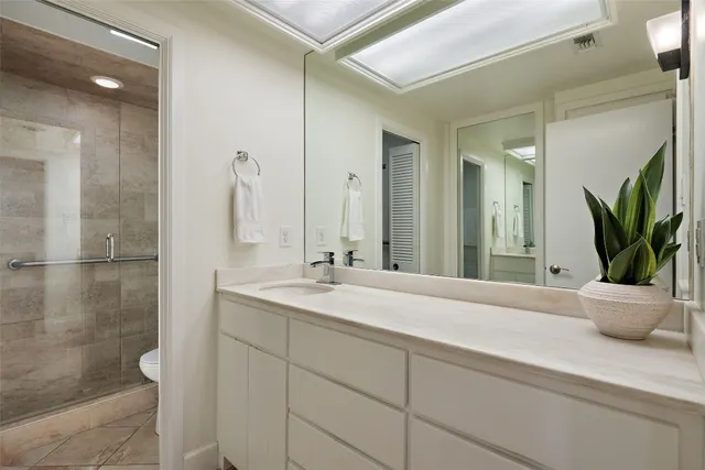 a bathroom with a granite countertop sink a large mirror and a shower