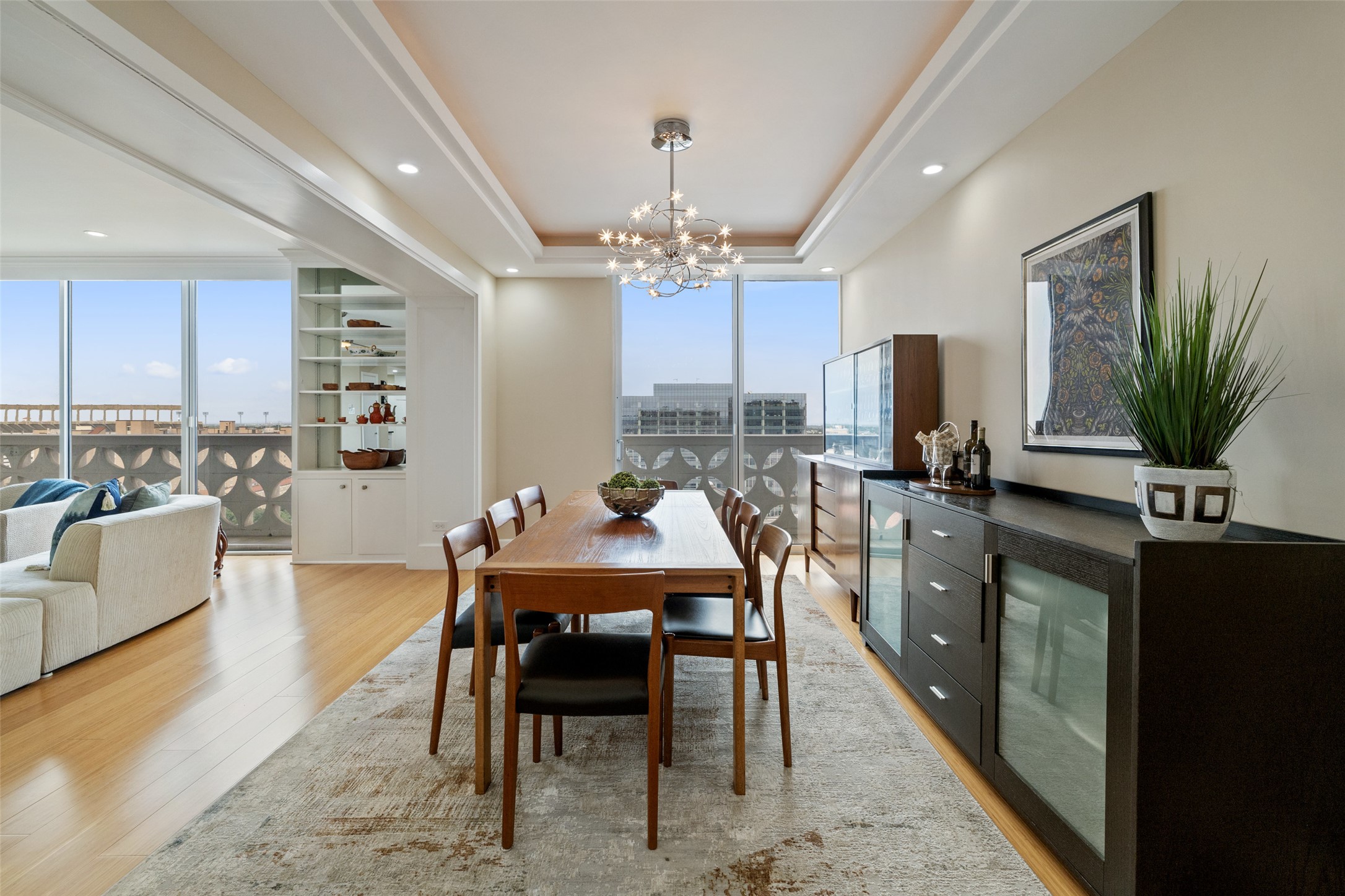 1801 Lavaca Street, Unit 13EF Austin, TX 78701 - Photo 20 of 40 Dining room with floor to ceiling windows, light wood finished floors, recessed lighting, a chandelier, and a tray ceiling