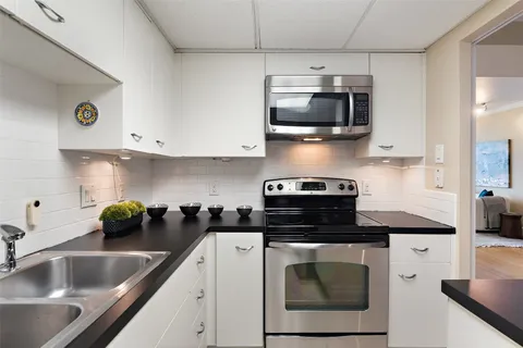 a kitchen with stainless steel appliances granite countertop a sink and a stove