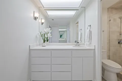 a bathroom with a sink a toilet and shower