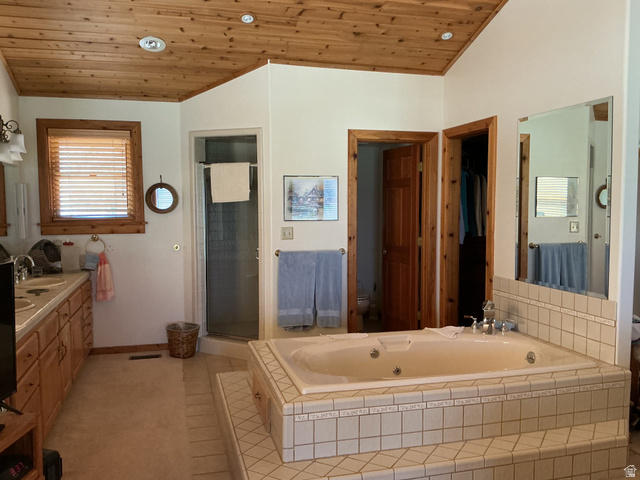 550 State Line Road Manila, UT 84046 - Photo 14 of 41 Spacious bathroom featuring a built-in jetted tub with tile surround, a corner glass-enclosed shower, and a dual-sink vanity with wood cabinetry