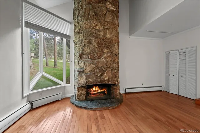 a view of an empty room and wooden floor and a window