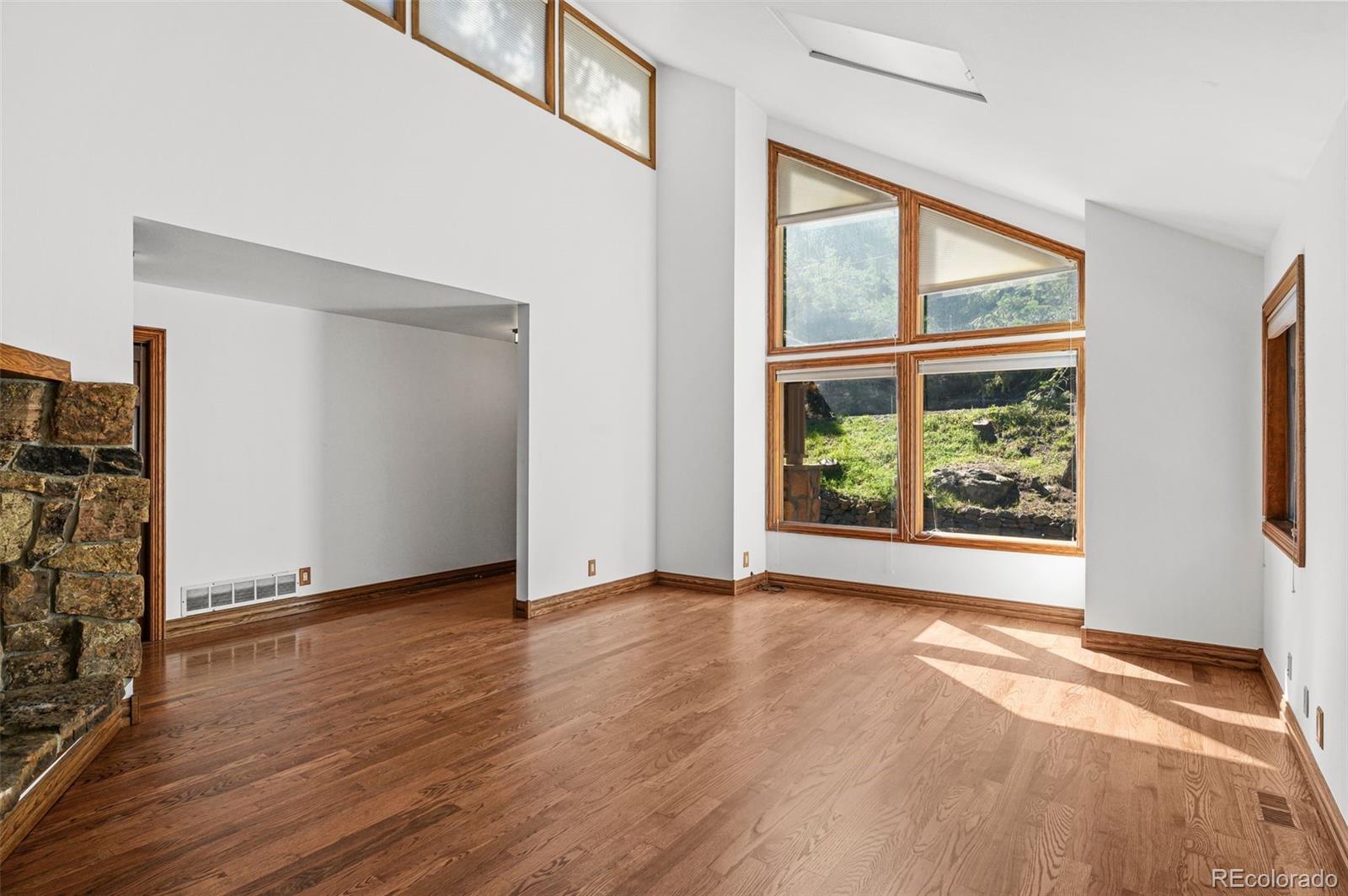 30243 Pine Crest Drive Evergreen, CO 80439 - Photo 11 of 36 a view of an empty room with wooden floor and a window