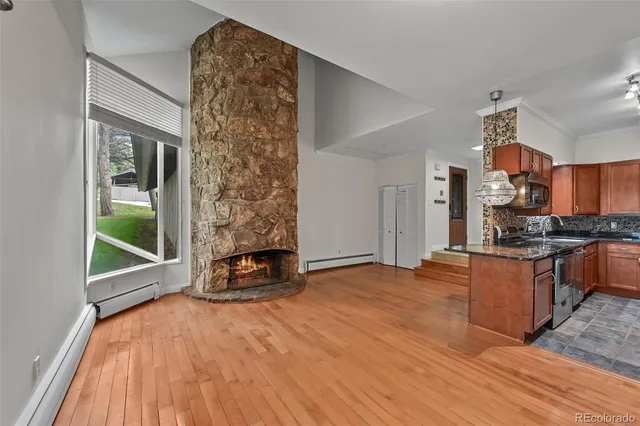 a living room with stainless steel appliances kitchen island granite countertop a stove a kitchen island a refrigerator and a sink