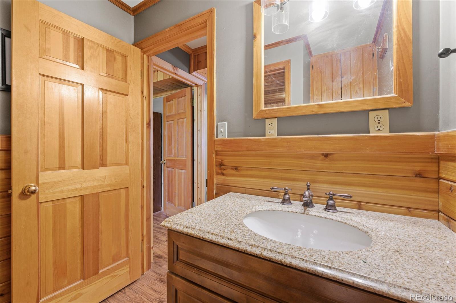 30243 Pine Crest Drive Evergreen, CO 80439 - Photo 16 of 36 a bathroom with a granite countertop sink and a mirror