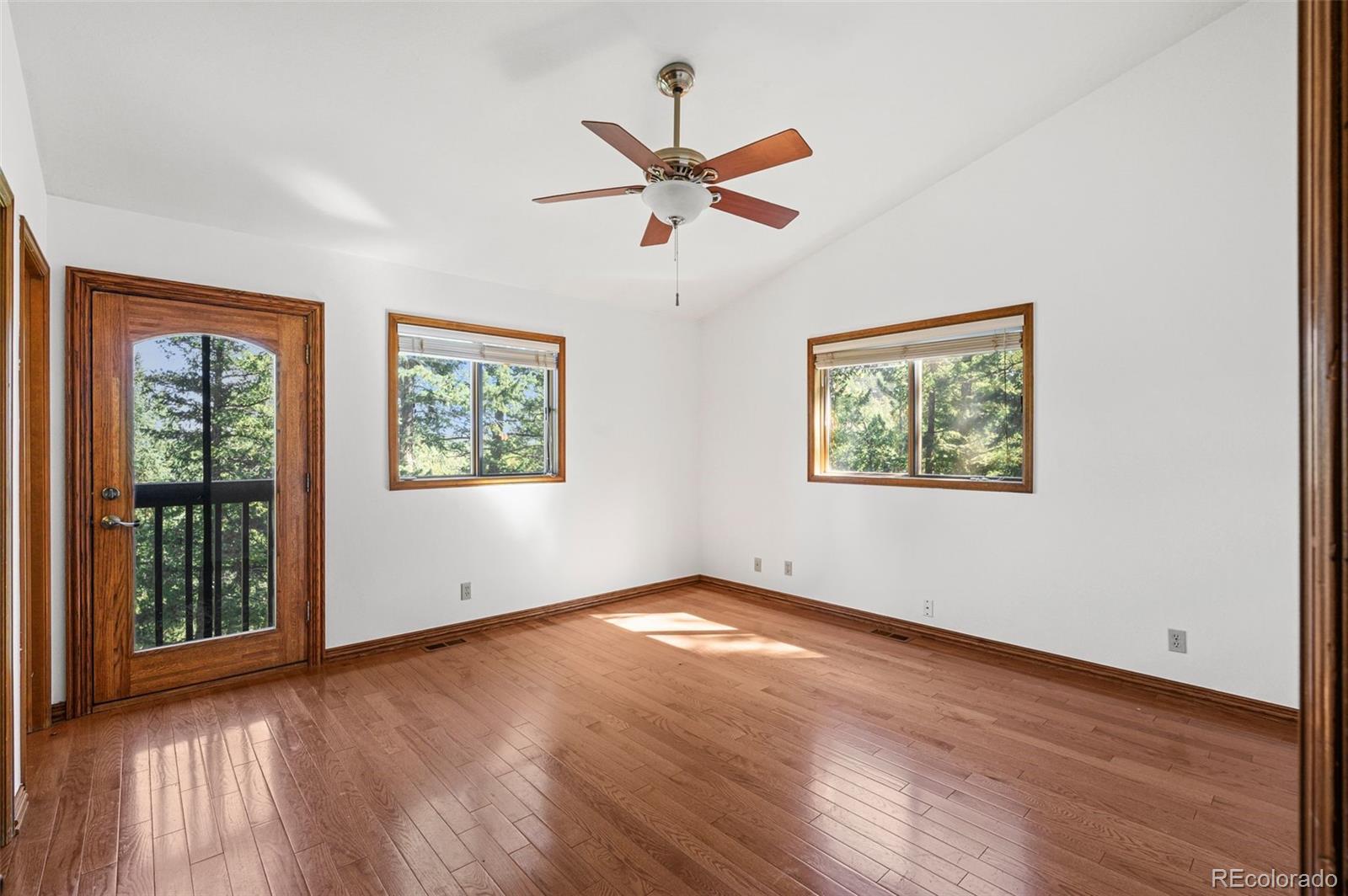 30243 Pine Crest Drive Evergreen, CO 80439 - Photo 21 of 36 a view of empty room with wooden floor and fan