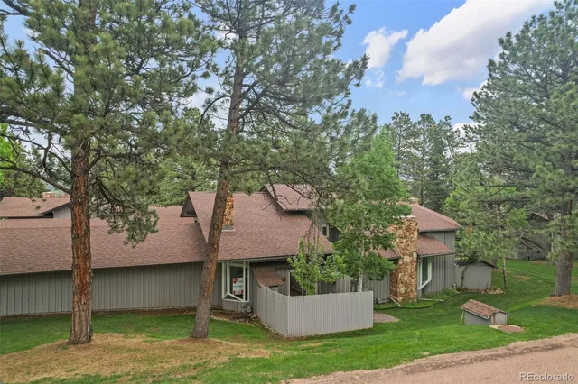 a view of a white house with a yard and a large tree