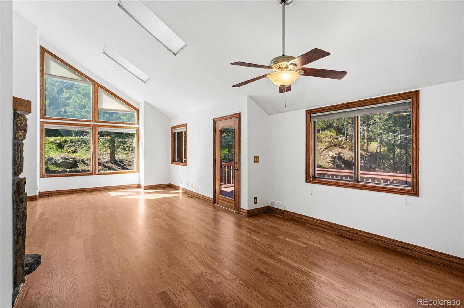 30243 Pine Crest Drive Evergreen, CO 80439 - Photo 9 of 36 a view of empty room with wooden floor and fan