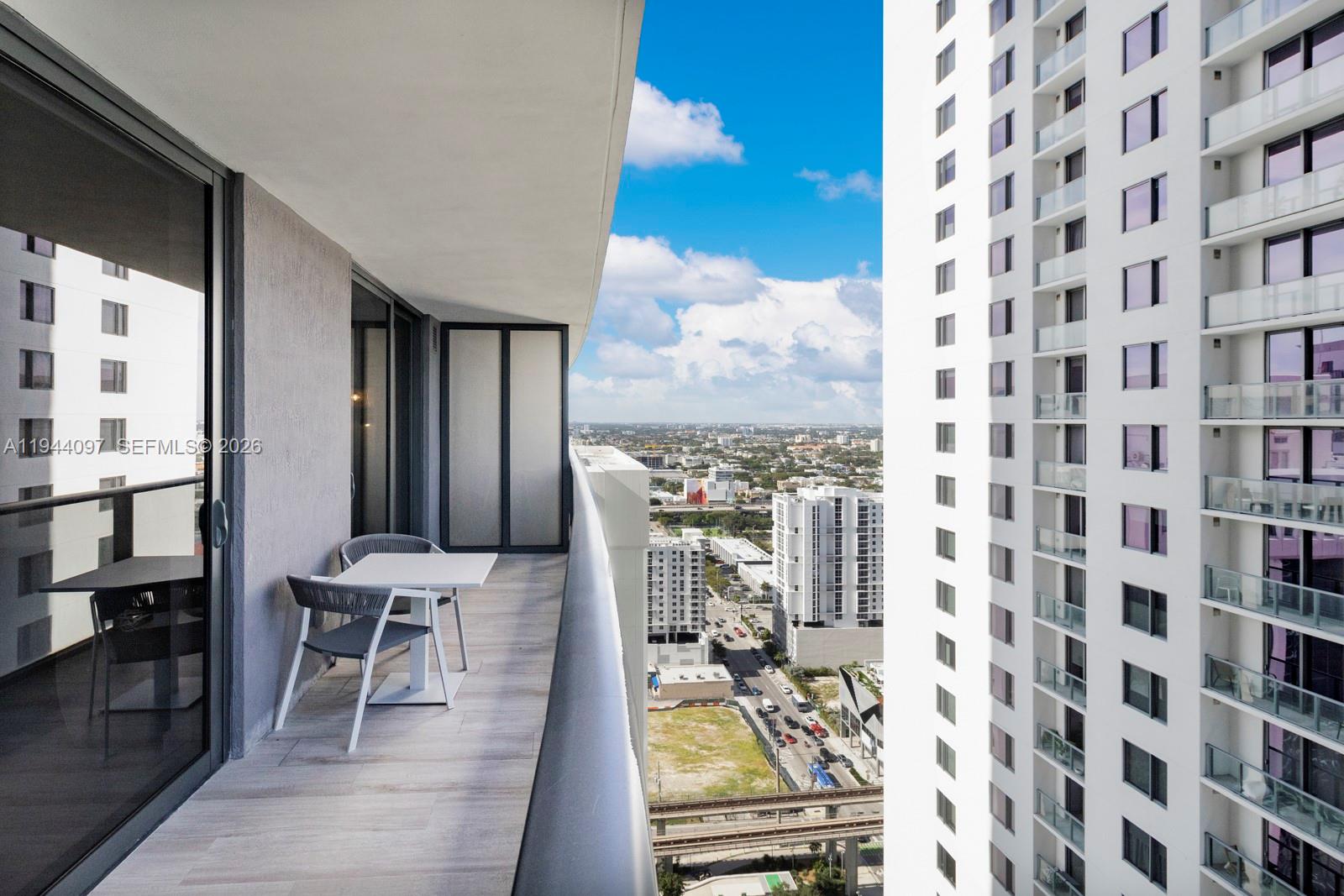 55 Southwest 9th Street, Unit 3010 Miami, FL 33130 - Photo 12 of 15 a view of a balcony with chairs and with furniture