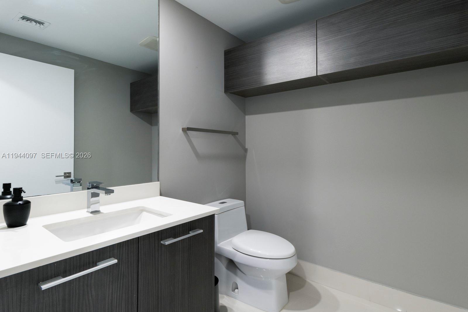 55 Southwest 9th Street, Unit 3010 Miami, FL 33130 - Photo 8 of 15 a bathroom with a sink mirror and toilet