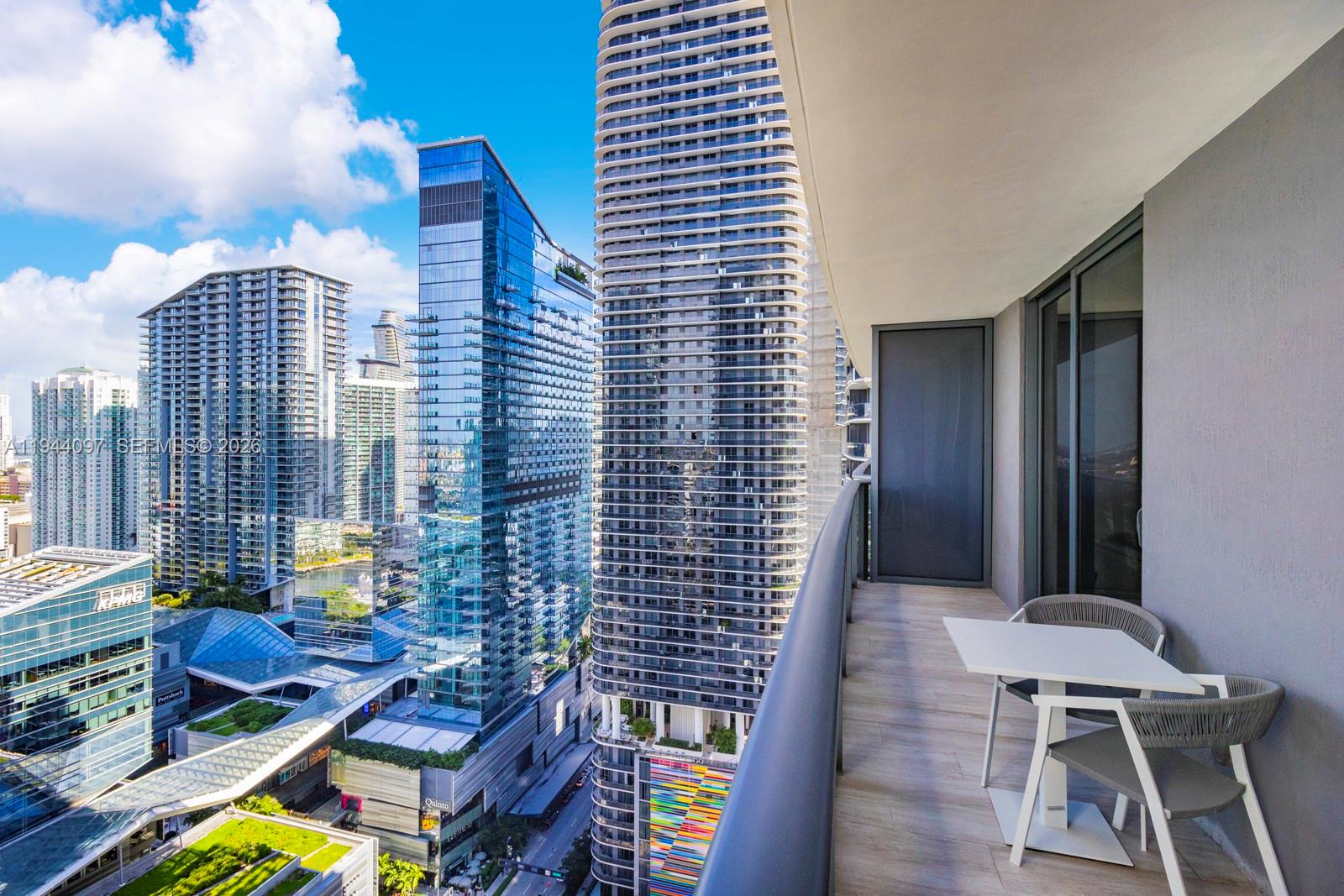 55 Southwest 9th Street, Unit 3010 Miami, FL 33130 - Photo 10 of 15 a balcony with chairs and wooden floor