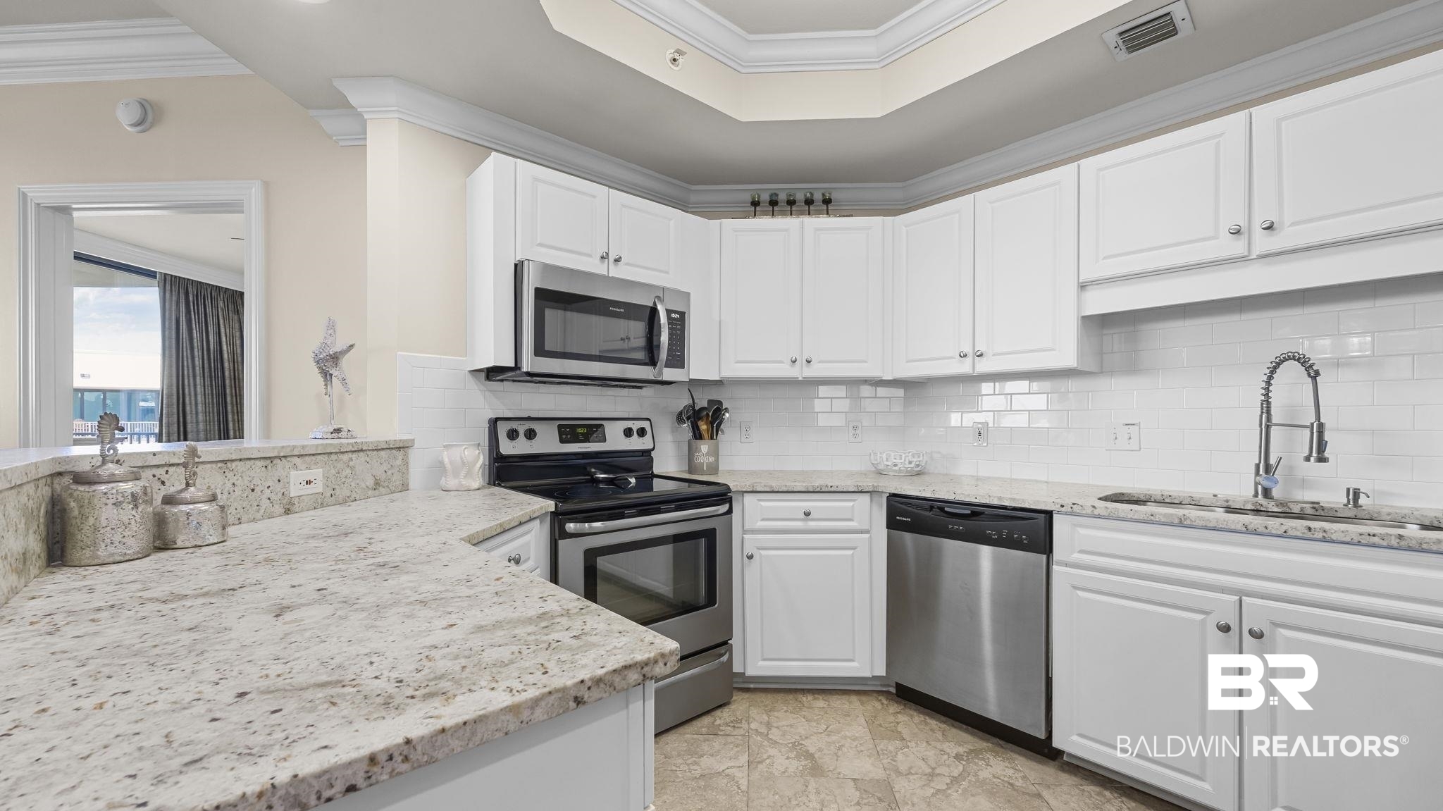 27580 Canal Road, Unit 1526 Orange Beach, AL 36561 - Photo 10 of 49 Kitchen featuring appliances with stainless steel finishes, backsplash, ornamental molding, and white cabinetry
