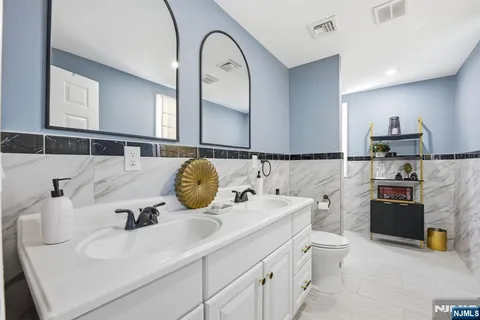 a bathroom with a granite countertop toilet sink and mirror