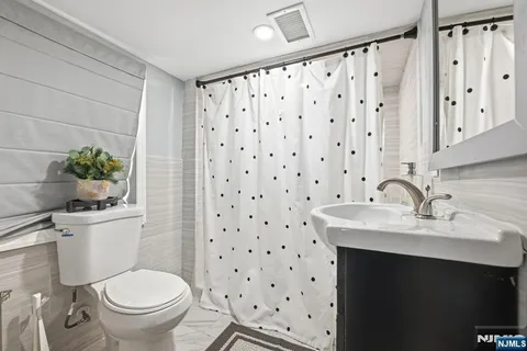 a bathroom with a sink toilet and a mirror