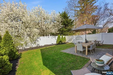 a view of a backyard with table and chairs under an umbrella