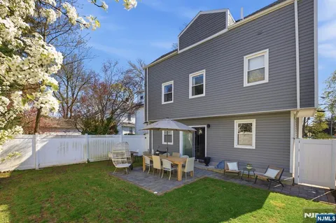 a view of a house with a backyard and chairs