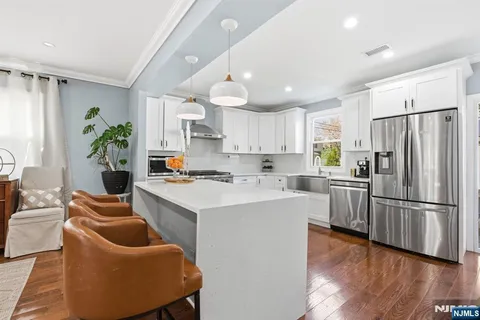 a kitchen with white cabinets and stainless steel appliances