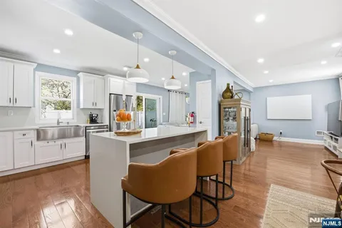 a kitchen with stainless steel appliances granite countertop a table chairs refrigerator and a sink