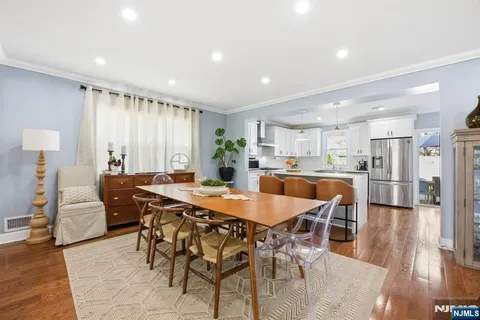 a dining room with stainless steel appliances a table and chairs